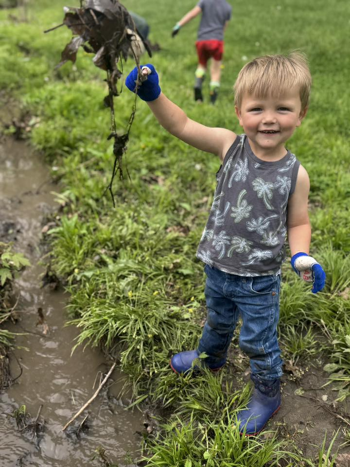 Happy toddler exploring in the mud at the farm